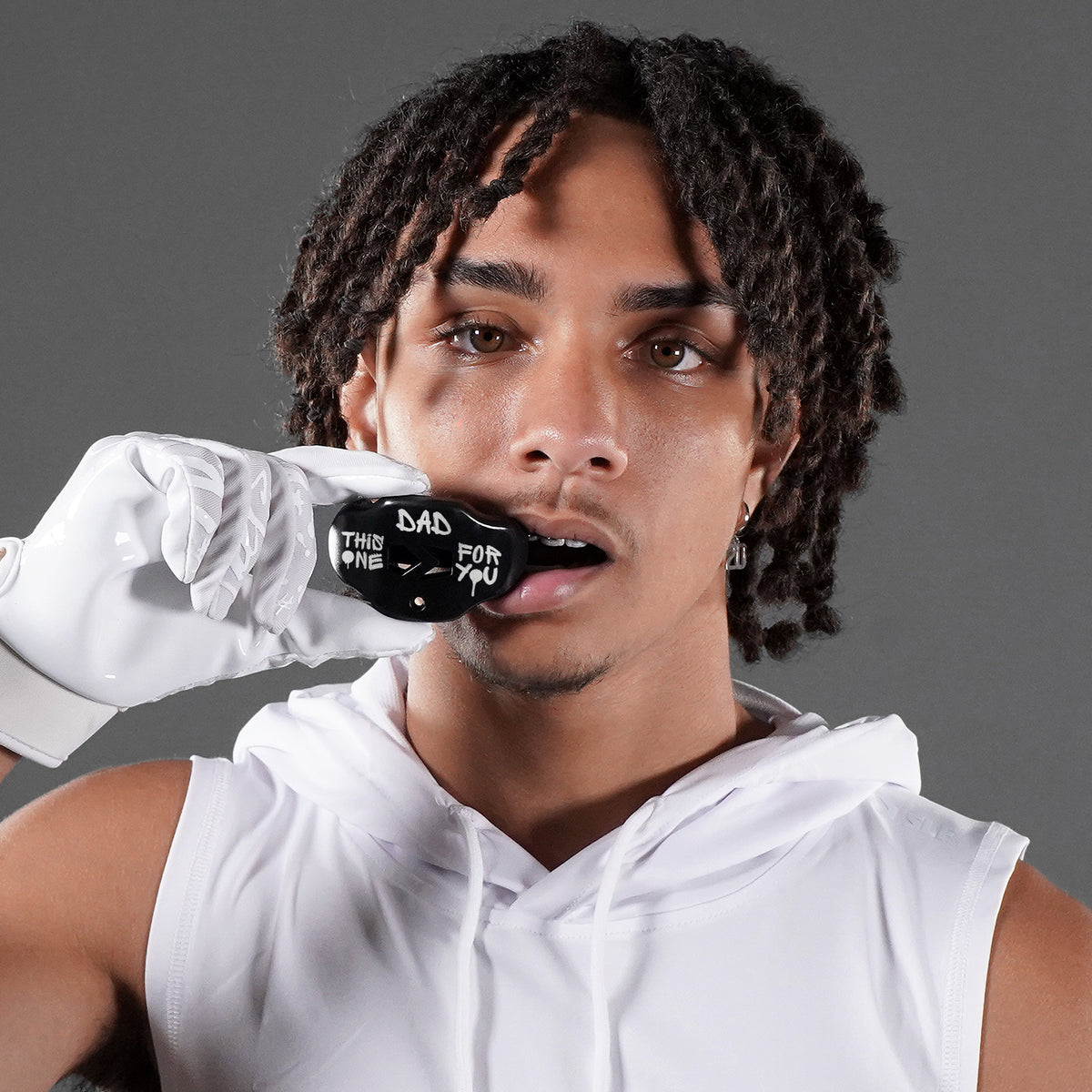 american football player with a SLEEFS mouthguard with white gloves and white  sleeveless hoodie
